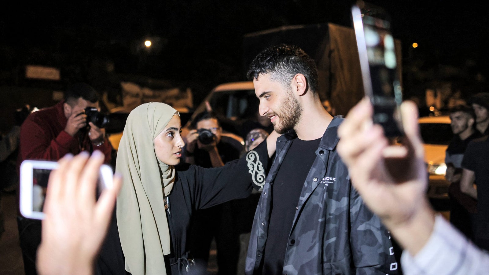 Palestinian activist twins, Mona and Mohammad el-Kurd, look at each other.