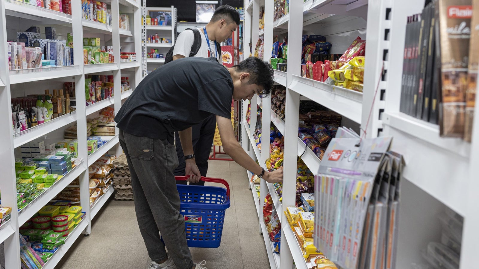 A photo showing people shopping in an isle at a grocery store.