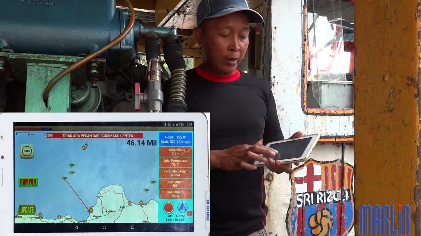 A photograph shows a man using a tablet neat a screen showing a map.