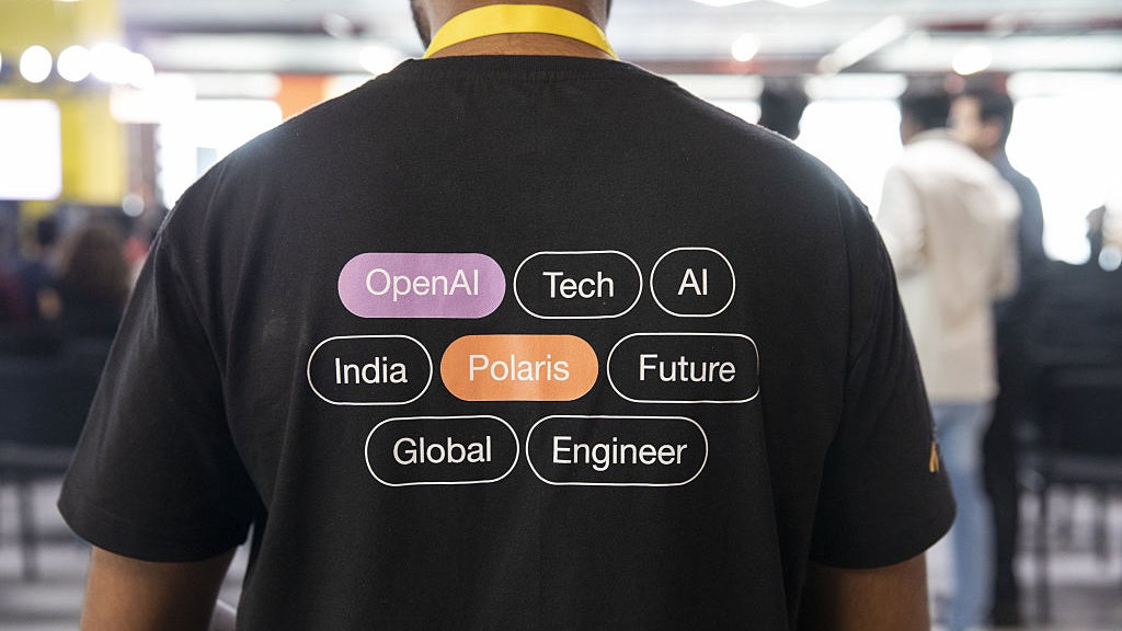 A person wearing a black t-shirt with text representing themes like OpenAI, Tech, AI, Polaris, and Global Engineer.