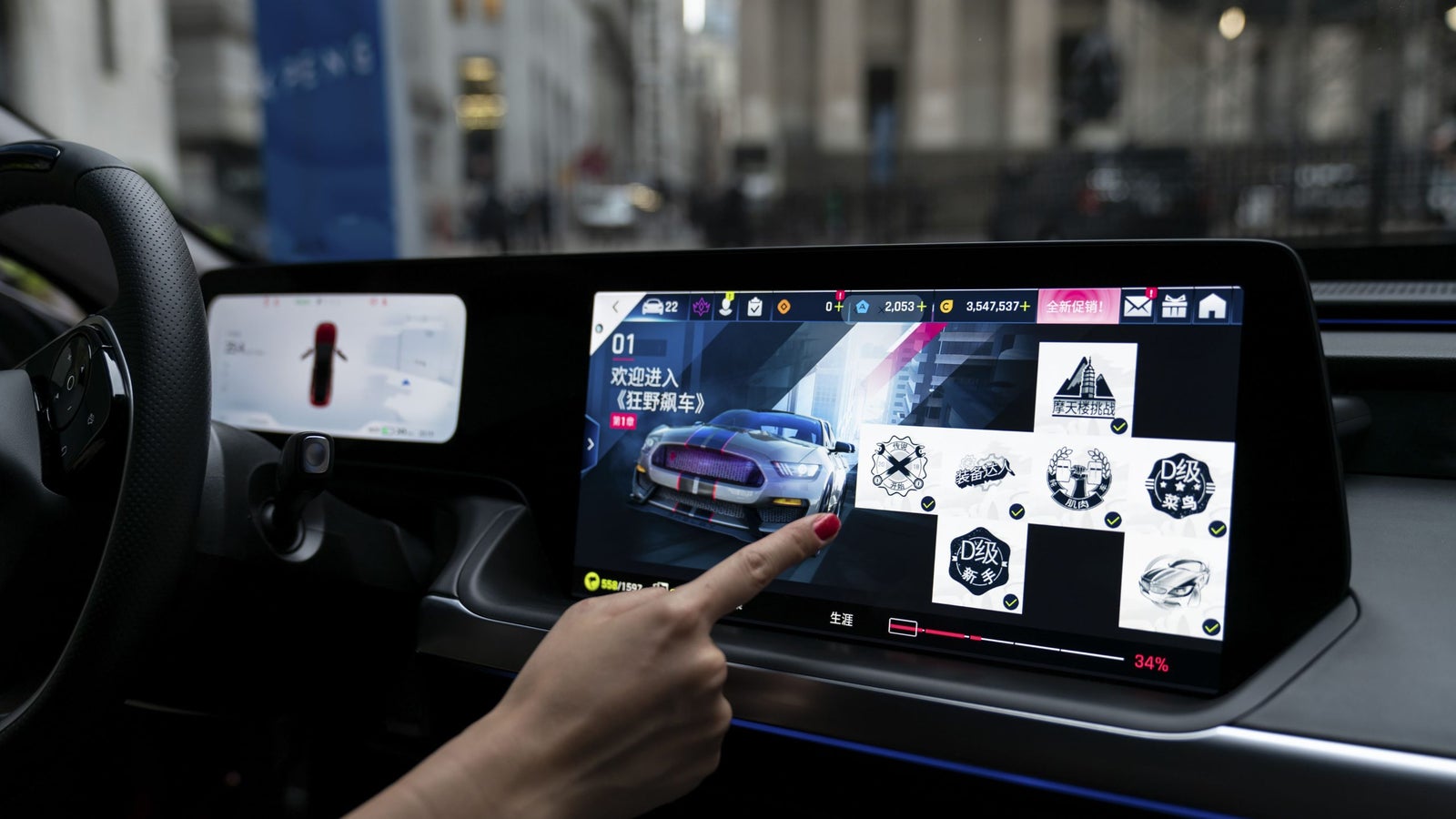 A hand interacting with a touchscreen display in a car, showcasing various app icons and a car image on the screen.